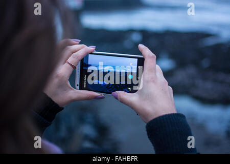 Aberystwyth, Pays de Galles, Royaume-Uni. Dec 30, 2015. Météo France : une pause dans la tempête Frank Aberystwyth, Pays de Galles, Royaume-Uni 20 décembre 2015. Pepole faire bon usage du temps s'il y a une rupture de l'averse que nous avons eu une grande partie de la journée avec storm Frank de passage. Une femme prend une photo de l'étourneaux volant autour. Credit : Trebuchet Photography/Alamy Live News Banque D'Images