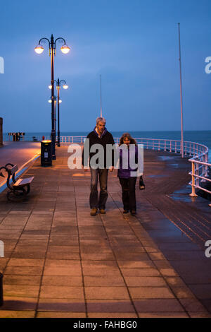 Aberystwyth, Pays de Galles, Royaume-Uni. Dec 30, 2015. Météo France : un couple marche main dans la main sur la Prom à sundown faisant bon usage de l'époque s'il y a une rupture de la pluie nous avons eu la plus grande partie de la journée en raison storm Frank de passage. Credit : Trebuchet Photography/Alamy Live News Banque D'Images