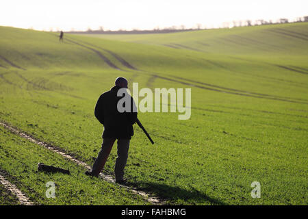 Un homme prenant position au cours d'un tournage d'hiver sur les terres agricoles dans la région de North Norfolk. Banque D'Images