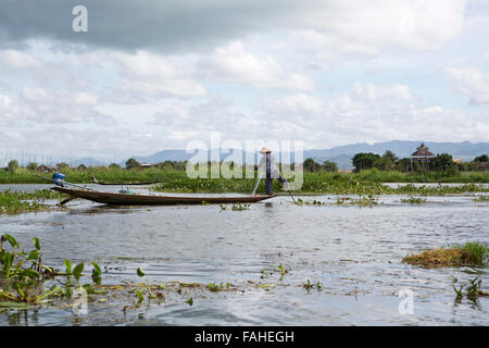 Un pêcheur de l'ethnie Intha people rowing son bateau sur le lac Inle au Myanmar (Birmanie). Banque D'Images