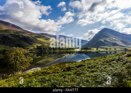 Buttermere Lake reflétant les collines environnantes par un beau jour ensoleillé au début de l'automne Banque D'Images