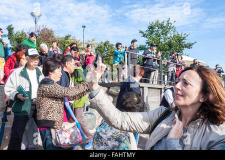 Caucasian woman entouré de touristes chinois prend avec selfies téléphone mobile en face de la statue de la Petite Sirène, Copenhague. Banque D'Images