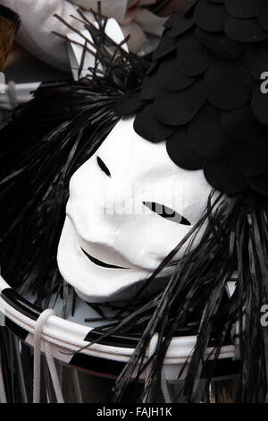 Un seul masque de carnaval de Bâle, montrant un visage de clown noir et blanc avec chapeau portant sur le dessus d'une caisse claire. Banque D'Images