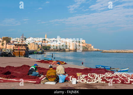 Fixation de filet de pêche des pêcheurs à Rabat port de pêche dans le fleuve Bou Regreg à l'embouchure de l'océan Atlantique. Rabat, Maroc. Banque D'Images