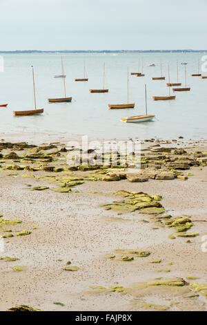 Les petits bateaux à voile voiliers en bois ou dingies amarrés dans le se sur l'île de Wight UK à marée basse Banque D'Images