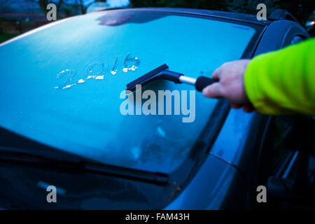 Personne dépose de la glace d'une voiture avec un pare-brise gelé Glace avec les mots écrits en 2016 dans la glace, Flintshire, au Pays de Galles Banque D'Images