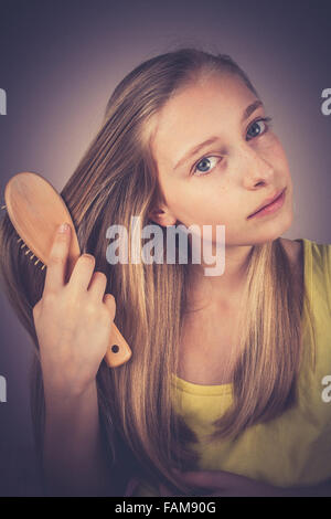 Blonde Fille peignant ses cheveux, effet de grain, vintage, old fashion Banque D'Images