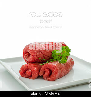 Trois roulades raw beef isolated on white plate, Close up Banque D'Images