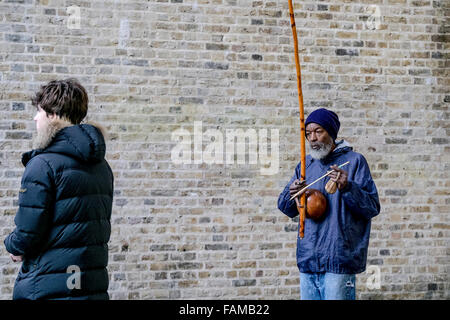 Sur la rive sud de Londres un musicien ambulant, Rabimsha joue un berimbau, un instrument traditionnel africain/brésilien. Banque D'Images