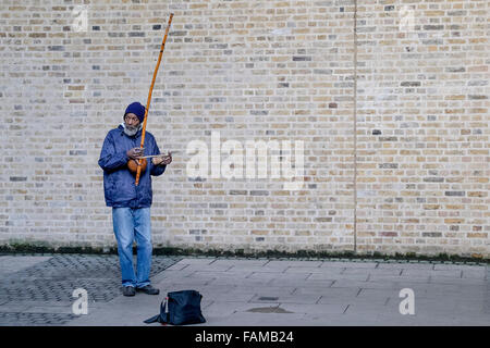 Sur la rive sud de Londres un musicien ambulant, Rabimsha joue un berimbau, un instrument traditionnel africain/brésilien. Banque D'Images