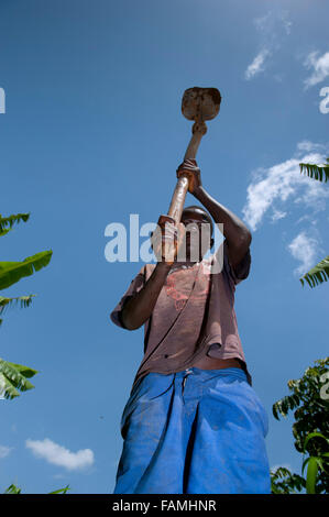 Jeune garçon travaillant dans le secteur avec une houe traditionnelle. Au Kenya. Banque D'Images