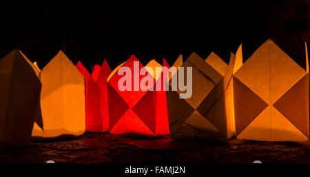 Rouge et jaune vif des bougies en papier, dans le noir Banque D'Images