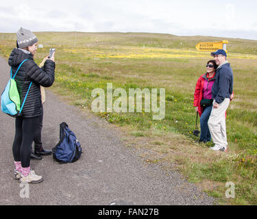 L'île de Grimsey, Islande. 31 juillet, 2015. Un couple de touristes ont leur photo prise par un panneau indiquant l'Cercle arctique sur l'océan Arctique île de Grimsey 40 km (24,8 mi) au large de l'île principale de l'Islande, à cheval sur le cercle arctique. Grimsey est le site touristique d'oiseaux destination. © Arnold Drapkin/ZUMA/Alamy Fil Live News Banque D'Images