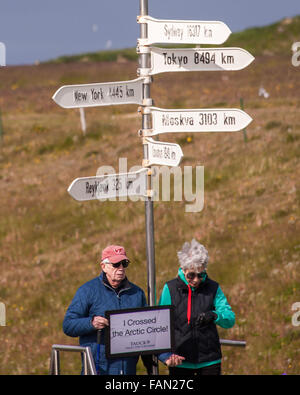 L'île de Grimsey, Islande. 31 juillet, 2015. Bateau de croisière touristique passagers posent deux ayant leur photo prise à un panneau indiquant qu'ils ont traversé le cercle arctique sur l'île de Grimsey 40 km (24,8 mi) au large de l'île principale de l'Islande. Dans l'océan Arctique, à cheval sur le cercle arctique, Grimsey est le site touristique d'oiseaux destination. © Arnold Drapkin/ZUMA/Alamy Fil Live News Banque D'Images