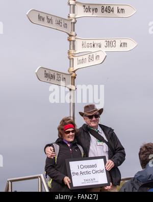 L'île de Grimsey, Islande. 31 juillet, 2015. Bateau de croisière touristique passagers posent deux ayant leur photo prise à un panneau indiquant qu'ils ont traversé le cercle arctique sur l'île de Grimsey 40 km (24,8 mi) au large de l'île principale de l'Islande. Dans l'océan Arctique, à cheval sur le cercle arctique, Grimsey est le site touristique d'oiseaux destination. © Arnold Drapkin/ZUMA/Alamy Fil Live News Banque D'Images