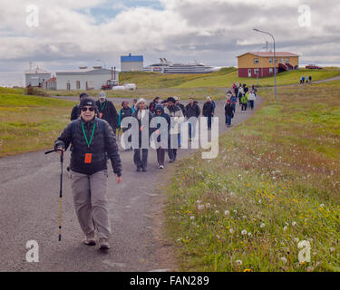 L'île de Grimsey, Islande. 31 juillet, 2015. Un groupe de passagers de navires de croisière randonnée Randonnée pédestre le long du terrain sans arbres de la roche volcanique de l'île de Grimsey 40 km (24,8 mi) au large de l'île principale de l'Islande. Dans l'océan Arctique, à cheval sur le cercle arctique. L'île de Grimsey est le site touristique d'oiseaux destination. © Arnold Drapkin/ZUMA/Alamy Fil Live News Banque D'Images