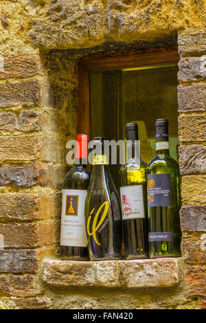 Des bouteilles de vin par fenêtre restaurant dans la vieille ville de Pienza, Toscane Banque D'Images