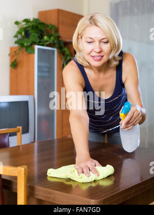 Table de nettoyage femme avec cleanser et rag dans son appartement Banque D'Images