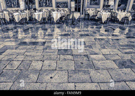 Tables de restaurant en plein air le matin pluie dans la Via Baldassarre Galuppi square, Ile de Burano Venise off Banque D'Images