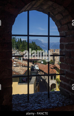 Vue sur le lac de Garde (Italie) et Sirmione vieille ville à travers la fenêtre de l'ancien Château Scaliger (Sirmione, Italie). Banque D'Images