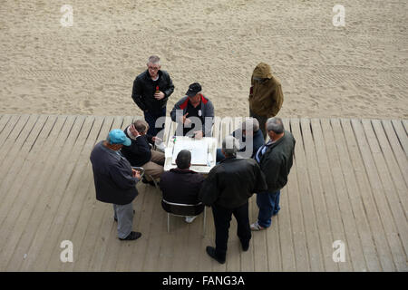 Groupe d'hommes retraités jouer aux dominos par Barcelona beach Banque D'Images