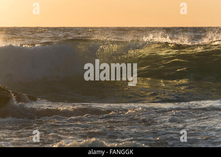 Les grandes vagues de l'océan transparent au lever du soleil, avec rétroéclairage et la couleur verte Banque D'Images