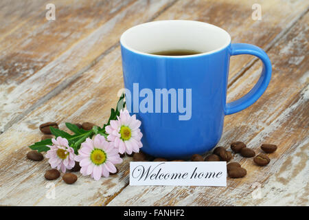 Bienvenue accueil carte avec grande tasse de café et de marguerites rose sur la surface en bois rustique Banque D'Images