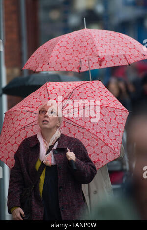 Aberystwyth, Pays de Galles, Royaume-Uni. 2 janvier, 2016. Météo France : Au lendemain de la tempête Frank, une femme à Aberystwyth abrite sous son parapluie à motifs rouge comme une bande de forte pluie se répand à travers de l'ouest, apportant plus de risques d'inondation dans le nord de l'Angleterre et l'Écosse Crédit photo : Keith Morris / Alamy Live News Banque D'Images