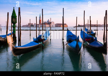 Les gondoles se sont attachées au crépuscule à San Marco avec San Giorgio Maggiore au loin, Venise, Italie Banque D'Images