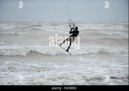 Un kite surfer jouit du mauvais temps et des conditions de vent au large de la côte à Goring par mer, West Sussex, Angleterre. Banque D'Images