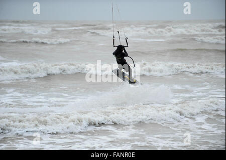 Un kite surfer jouit du mauvais temps et des conditions de vent au large de la côte à Goring par mer, West Sussex, Angleterre. Banque D'Images