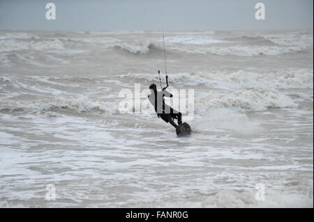 Un kite surfer jouit du mauvais temps et des conditions de vent au large de la côte à Goring par mer, West Sussex, Angleterre. Banque D'Images