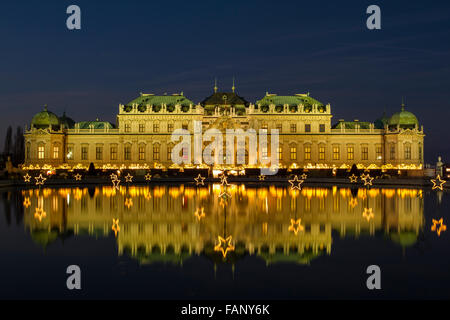 Marché de Noël avec des lumières de Noël en face du Palais du Belvédère, la réflexion dans le lac, Vienne, Autriche Banque D'Images