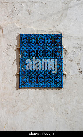 Fenêtre fer bleu traditionnel sur un mur blanc de la Kasbah de l'Udayas à Rabat, Maroc. Banque D'Images