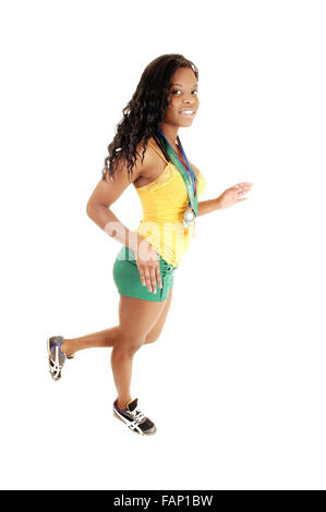 Une jolie black girl walking in the studio en vert et jaune short top avec ses 4 médailles sportives autour du cou, pour whit Banque D'Images