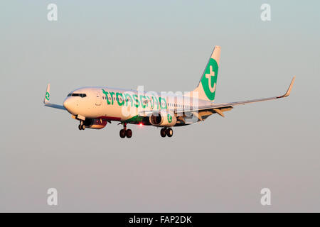 Boeing 737-800 de Transavia la compagnie aérienne dans l'approche révisée sur les couleurs au coucher du soleil avec des feux à éclats Banque D'Images