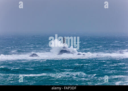 Vagues se brisant sur le phare de Drakkars. Lands End, Cornwall, UK. Des vents forts, des rafales de l'HPM 60, 2 janvier 2016. Credit : Barry Bateman / Alamy Live News Banque D'Images