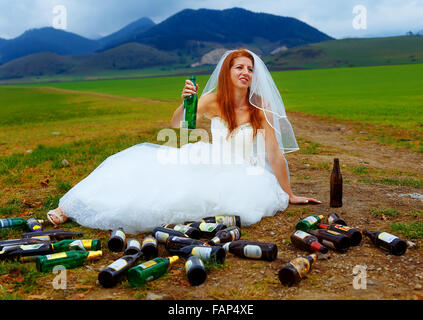 Drunken mariée avec beaucoup de bouteilles de bière vides dans paysage de montagnes - concept de mariage drôle Banque D'Images