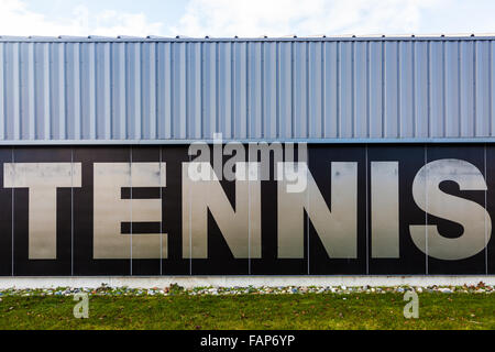 Grand signe graphique sur le mur extérieur d'un terrain de tennis Banque D'Images