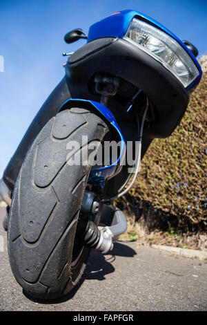 Motor scooter, Italjet Dragster 180 vélo classique. Grand angle faible vue avant de la roue avant et le phare. Ciel bleu clair et l'arrière-plan de couverture. Banque D'Images