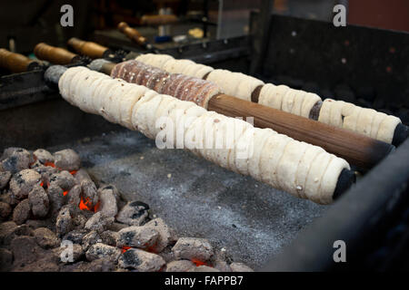 Trdelník étals. Les Trdelnik est une masse de farine, le sucre, l'oeuf, la levure, la cannelle et le lait qui est étiré et enroulé sur un sol en bois Banque D'Images