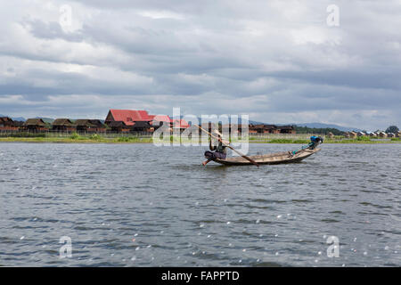 Un pêcheur de l'ethnie Intha people rowing son bateau sur le lac Inle au Myanmar (Birmanie). Banque D'Images