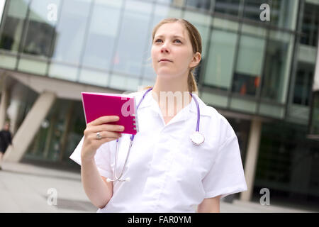 Jeune médecin détenant un bloc-notes à la une Banque D'Images