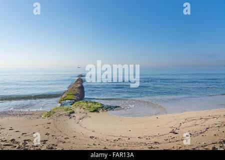 Forme d'onde en spirale, la pierre jetée et voilier à Majorque, îles Baléares, Espagne Banque D'Images