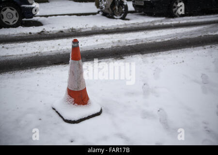 Cône de la route au milieu de la rue couverte de neige. Banque D'Images