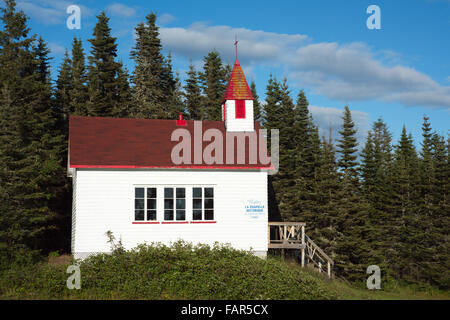 Chapelle au nord-est de Québec Canada à Pointe-des-Monts avec toile de fond de The Evergreens et ciel bleu avec des nuages épars. Banque D'Images