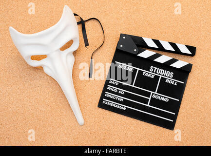 Masque de carnaval blanc et film clapper board cork sur fond de bois Banque D'Images