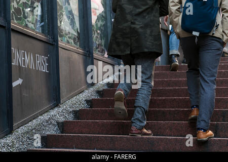 Les piétons passent devant un cinéma Lieu pancarte sur l'affichage à l'extérieur de son immeuble à Shibuya le 4 janvier 2016, Tokyo, Japon. La mini theatre populaire qui a porté sur les films international a annoncé qu'il fermera ses portes en janvier dernier. Le théâtre a été conçu par l'architecte japonais, Atsushi Kitagawara, et construit en 1986. © Rodrigo Reyes Marin/AFLO/Alamy Live News Banque D'Images