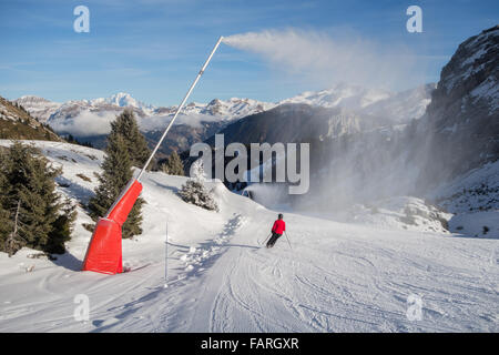 Courchevel 1850, France - un skieur passe sous l'une des 2100 canons à neige artificielle à la fois de faibles chutes de neige Banque D'Images