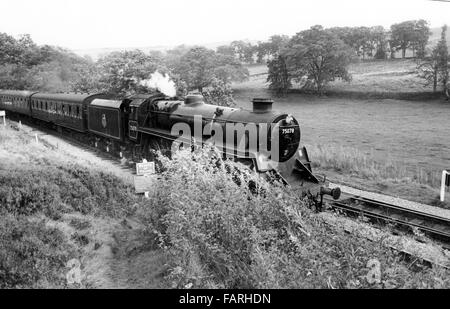 Ferme de crossing, West Yorkshire vers 1982 Photographie noir et blanc image d'archive. Accueil de la Concon et chemin de fer de la vallée d'une valeur, le KWVR est assuré par des bénévoles. BRITISH RAILWAYS STANDARD CLASS 4MT 4-6-0 NO75078. Achevée en 1956, 75078 est l'un d'une classe de 80 moteurs construits à une norme British Railways design. Banque D'Images